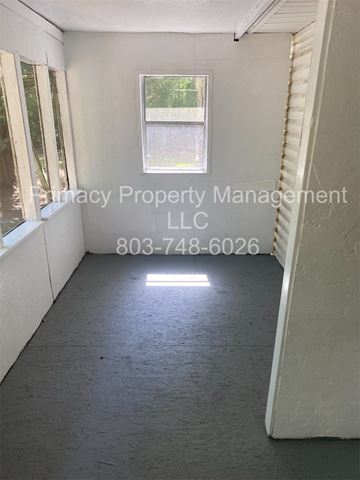 Andrews house for rent - A room with a window and a phone number for a property management company.