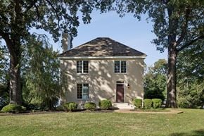 Newport News house for rent - A small house with a brown door is surrounded by trees.
