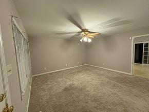 Garner house for rent - A room with a ceiling fan and carpeted floor.