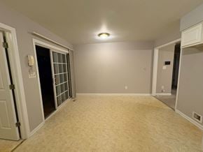 Garner house for rent - A room with a carpeted floor and a door leading to a dark space.