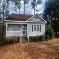 Garner house for rent - A small white house with a brown roof and a porch.