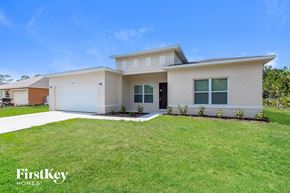 Palm Bay house for rent - A modern house with a white garage door and a brown garage door.