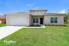 Palm Bay house for rent - A modern house with a white garage door and a black front door.