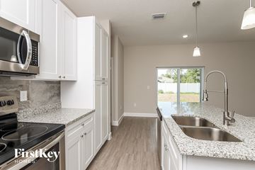 Palm Bay house for rent - A kitchen with white cabinets and a granite countertop.