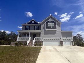 Raeford house for rent - A two-story house with a garage and a covered porch.