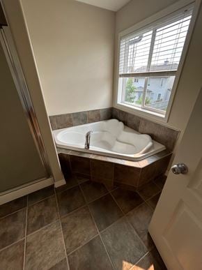 Edmonton house for rent - a large soaking tub in a bathroom with a window