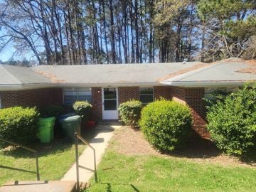 Raleigh house for rent - A house with a green lawn and a red brick wall.