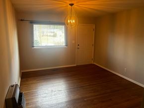 Garner house for rent - A room with a wooden floor and a window with blinds.