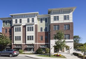 Jersey City apartment for rent - A modern apartment building with a clear blue sky in the background.