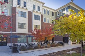 Jersey City apartment for rent - a courtyard with tables and umbrellas in front of a building