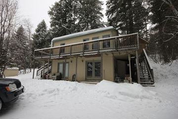 Whitefish apartment for rent - A house with a balcony covered in snow.