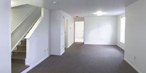 Bridgeton townhouse for rent - an empty living room with a staircase and white walls
