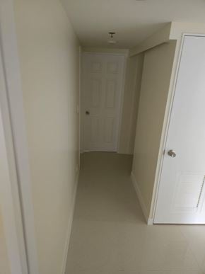 Mangilao apartment for rent - A white door is in a hallway with a white wall.