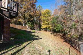 Fayetteville house for rent - A backyard with a fence and trees in autumn colors.