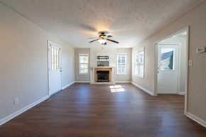 Fayetteville house for rent - A living room with a fireplace and a ceiling fan.