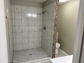 Fayetteville house for rent - A bathroom with a tiled shower and a toilet.