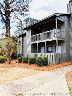 Fayetteville house for rent - A two-story building with a balcony and a fence in front.
