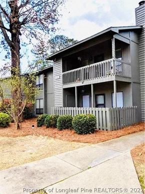 Fayetteville house for rent - A two-story building with a balcony and a fence in front.
