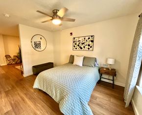 Austin apartment for rent - a bedroom with a large bed and a ceiling fan