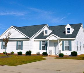 Wake Forest apartment for rent - A white house with a black roof and a small tree in front.