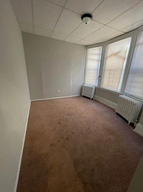 Philadelphia apartment for rent - an empty room with a carpet and three windows