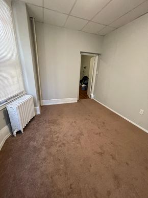 Philadelphia apartment for rent - a living room with a carpeted floor and a radiator