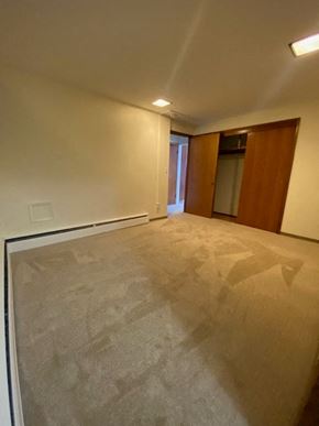 Anchorage apartment for rent - A room with a carpeted floor and a door on the right side.