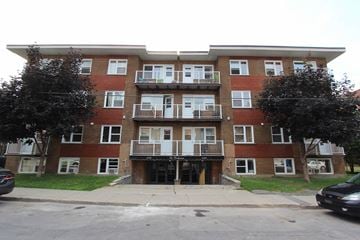 Verdun apartment for rent - a brick apartment building with three floors and balconies