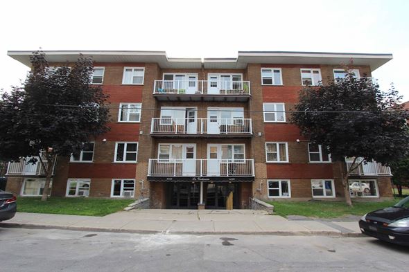 Verdun apartment for rent - a brick apartment building with three floors and balconies