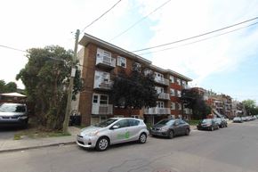 Verdun apartment for rent - a city street with cars parked in front of an apartment building