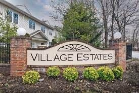 Amityville apartment for rent - a sign for village estates in front of a house