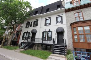 Montreal apartment for rent - a white house with black shutters on a city street