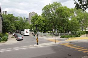 Montreal apartment for rent - a bus driving down a city street with cars and trees