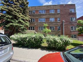 Montreal apartment for rent - a red brick building with bushes in front of it