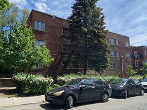 Montreal apartment for rent - the apartment building has three cars parked in front of it