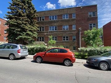 Montreal apartment for rent - a red car parked in front of a brick building