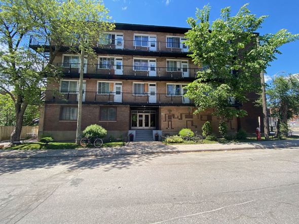 Montreal apartment for rent - a large brick apartment building with a street in front