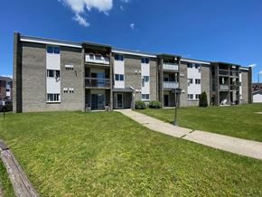 Granby apartment for rent - an apartment building with green grass and a sidewalk