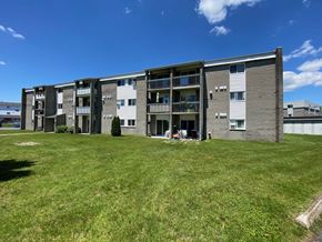 Granby apartment for rent - an apartment building with a green lawn in front of it