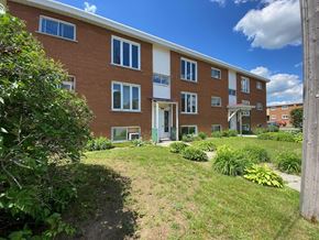 Granby apartment for rent - the front of a brick apartment building with a green yard