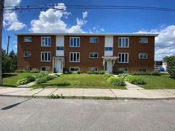 Granby apartment for rent - a large brick building with a lawn in front of it