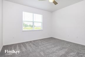 Kissimmee house for rent - the living room of a home with a carpeted floor and a window