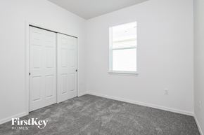 Kissimmee house for rent - a bedroom with white walls and carpet and a window and white doors