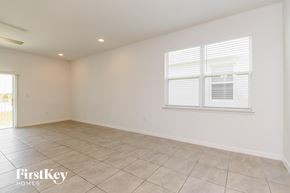 Kissimmee house for rent - A spacious room with a window and tiled floor.