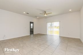 Kissimmee house for rent - A spacious room with a ceiling fan and a door leading to a balcony.