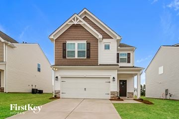 Greenville house for rent - a beige and brown house with a white garage door