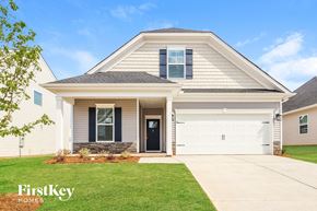 Greenville house for rent - a white house with a garage door and a lawn
