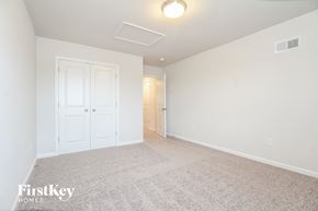 Greenville house for rent - a spacious living room with a carpeted floor and a white door to a hallway