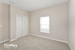Palm Coast house for rent - a bedroom with beige carpet and white doors and a window