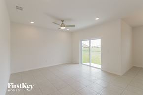Bartow house for rent - A spacious empty room with a ceiling fan and sliding glass doors.